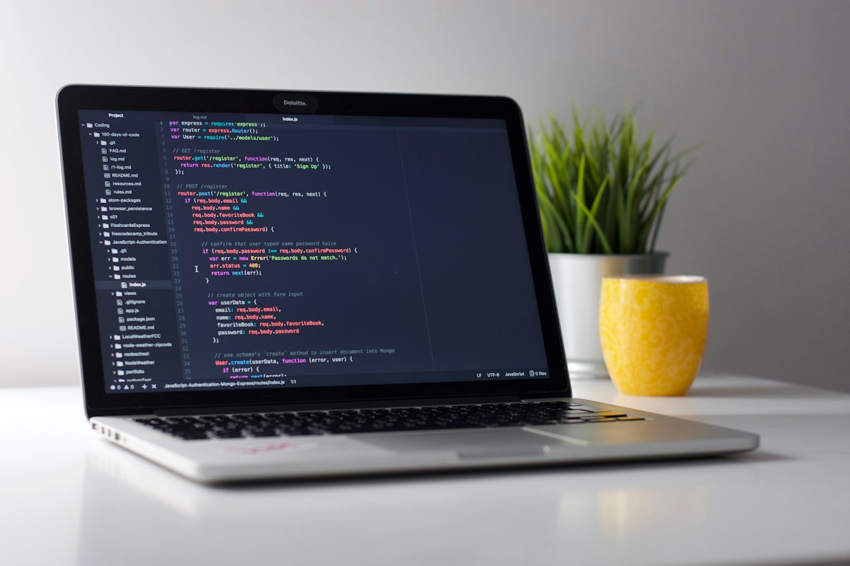 Laptop showing code on a white desk