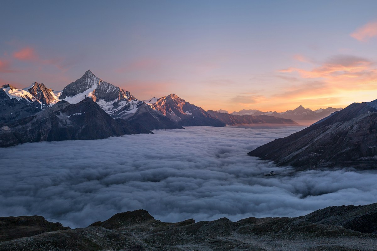 Mountain peaks above the clouds at sunset